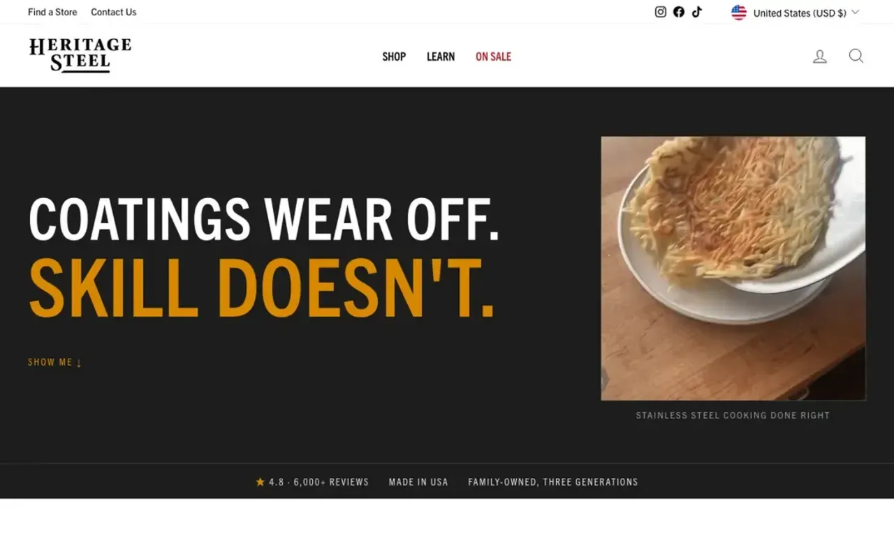 Top of Heritage Steel's page with the opening line Coatings wear off. Skill doesn't., a Show Me link, a photo of a crisp potato cake sliding off a pan onto a plate captioned Stainless steel cooking done right, and a strip reading 4.8, 6,000+ reviews, Made in USA, Family-owned, three generations